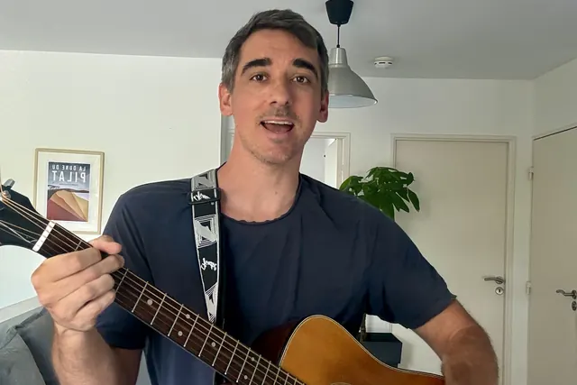 Quentin, prof de basse à Marseille, à la guitare acoustique en train de chanter